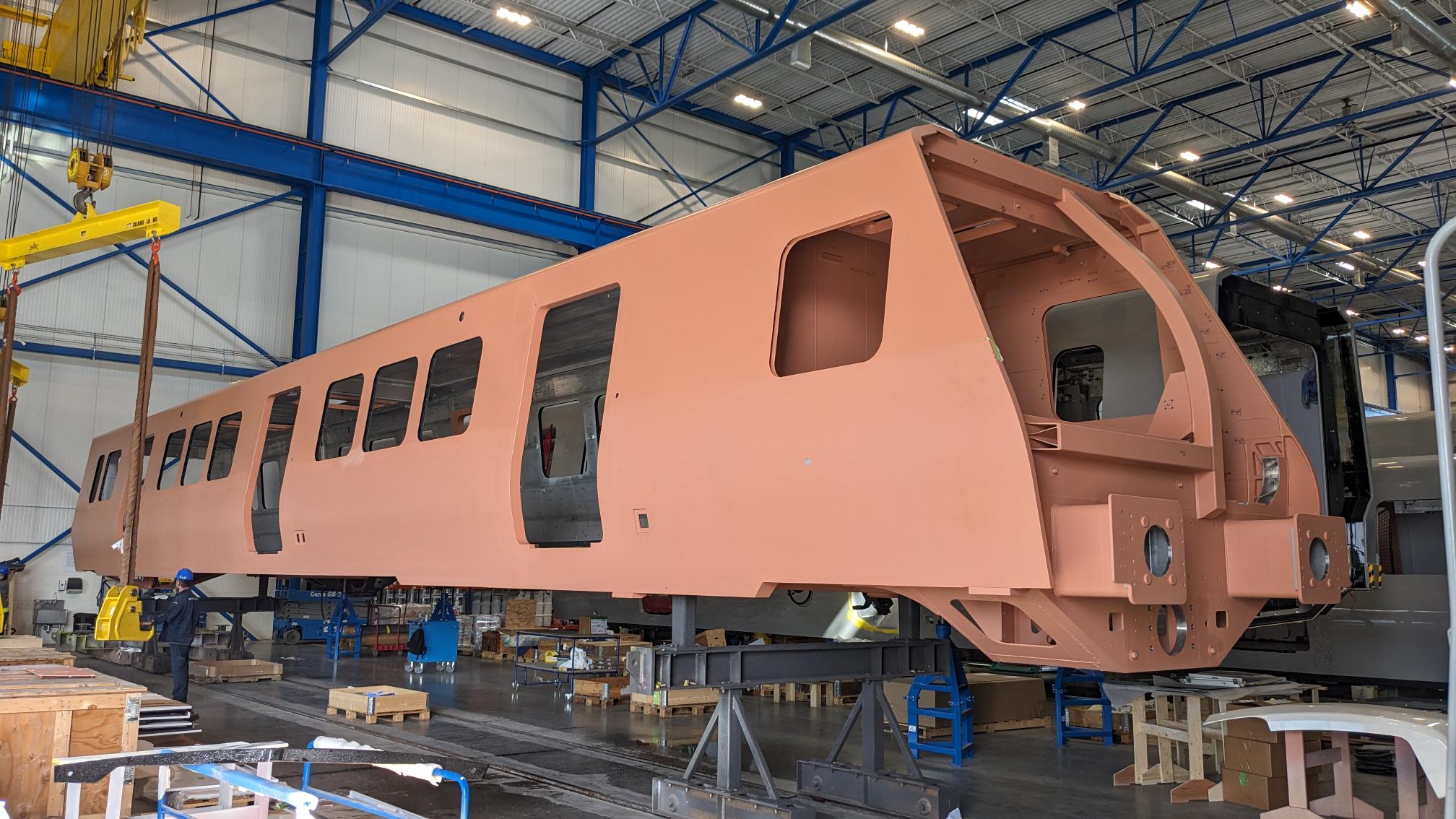 An unfinished train body in a factory before its windows and outer finish are added