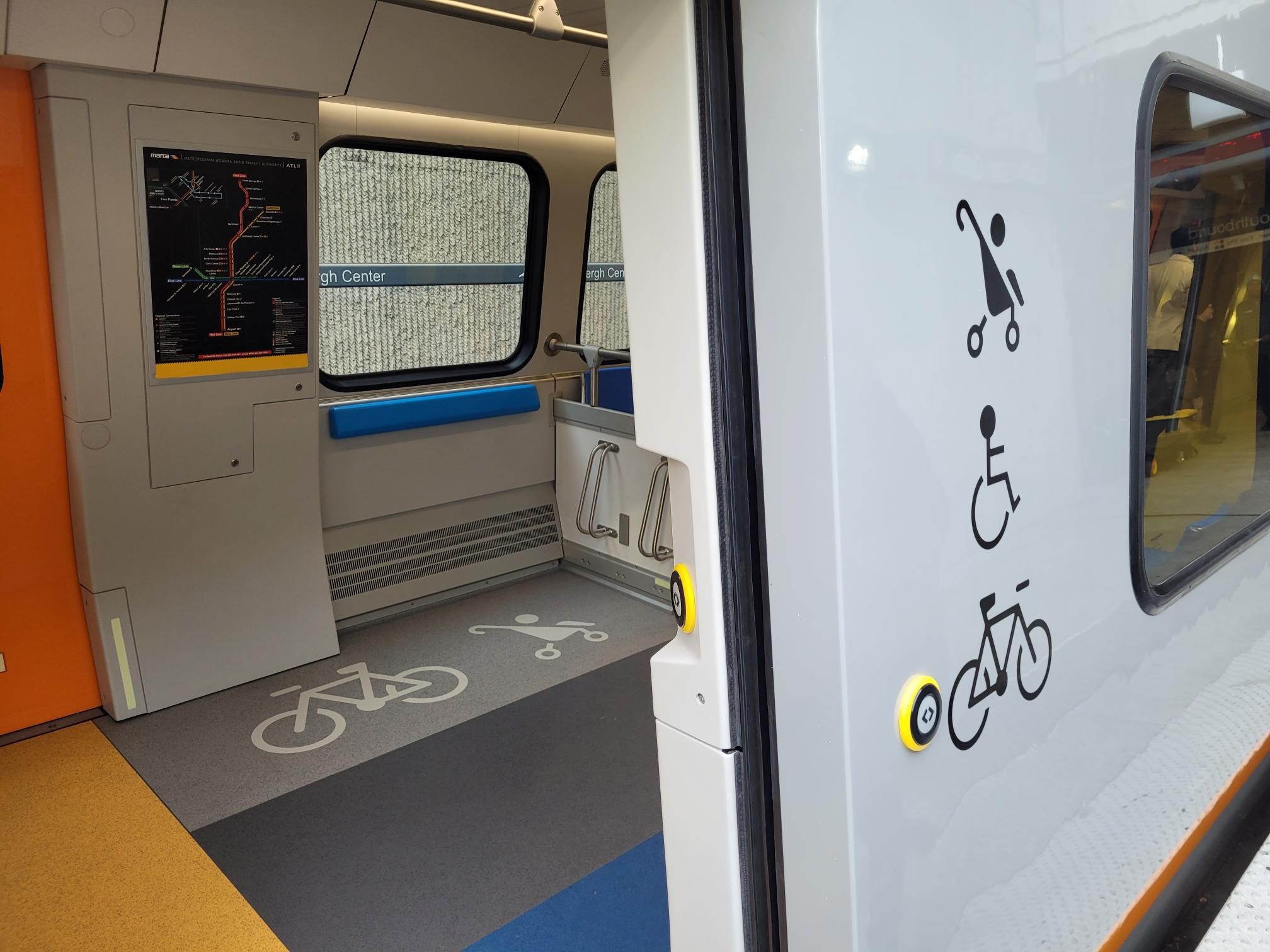 Symbols at a CQ400 train entrance mark space for wheelchairs, strollers and bicycles